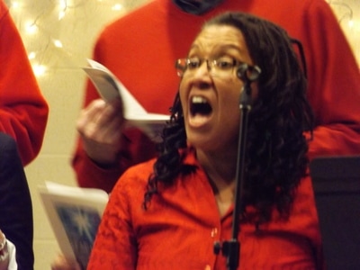 Woman singing in choir.

