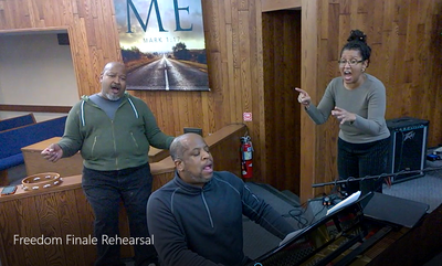Three singers rehearsing at piano.