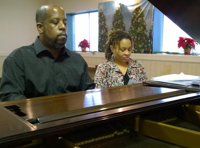 Husband, wife play piano duet.