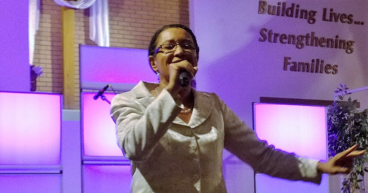 Woman singing with microphone.